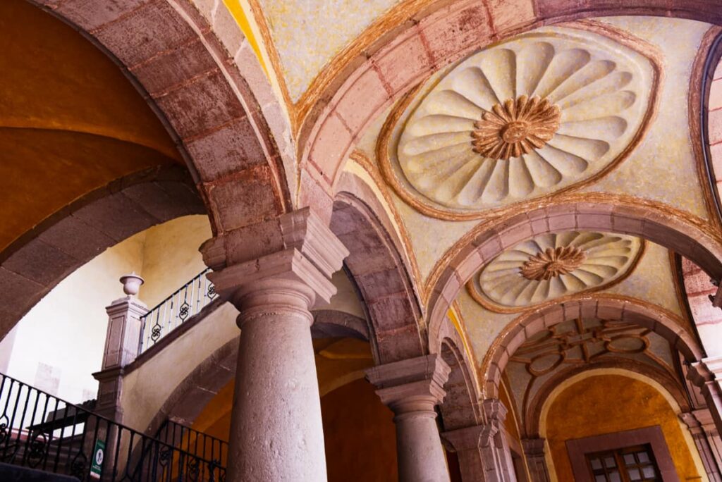 The simple but stunning arches at the Queretaro Regional Museum are flanked with columns. In the background is the staircase that leads up to this Queretaro museum.