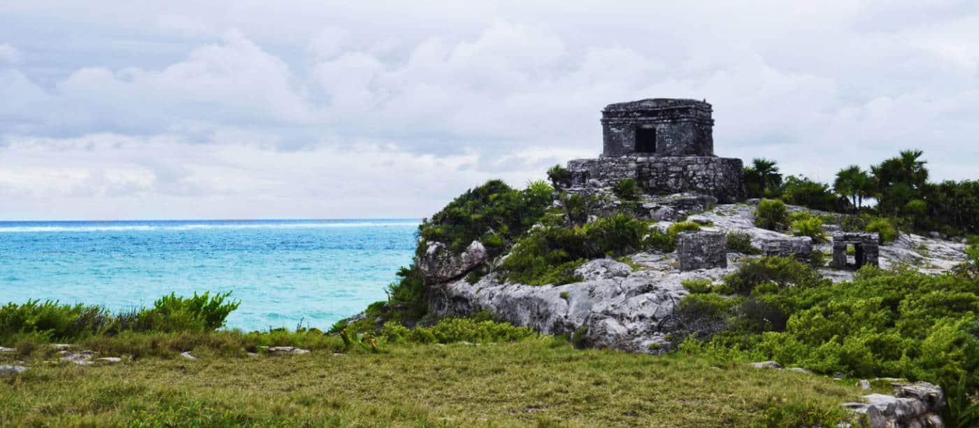 View of Tulum ruins, located in the Yucatan, with the turquoise Caribbean Sea in the background.
