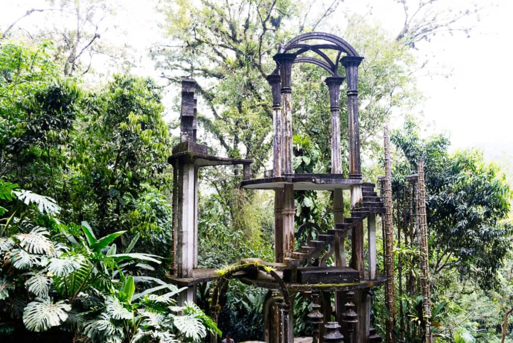 An open concrete structure with archways and stairs sits among the forest at the Edward James Surrealist Garden in Xilitla, one of the best tours in Huasteca Potosina.