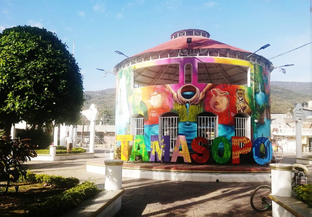 A circular kiosk in the center of the square in Tamasopo is very colorfully painted with depictions of the area. In front are colorful letters that read Tamasopo.