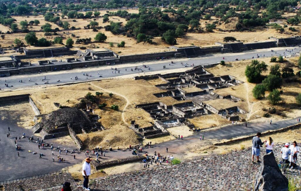 From the top of the pyramid of the moon, an overview shot of the Avenue of the Dead and smaller Teotihuacan pyramids in between.