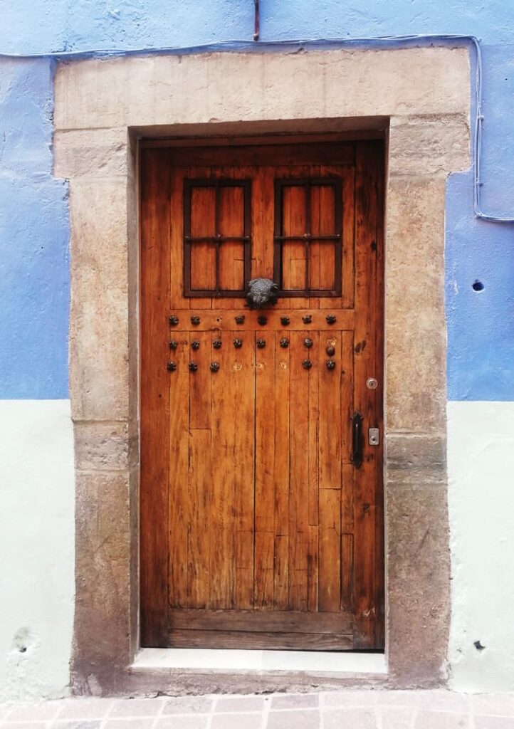 In Guanajuato capital, there are many frog statues, including this wooden door that features a large metal frog with several rows of smaller frogs underneath.