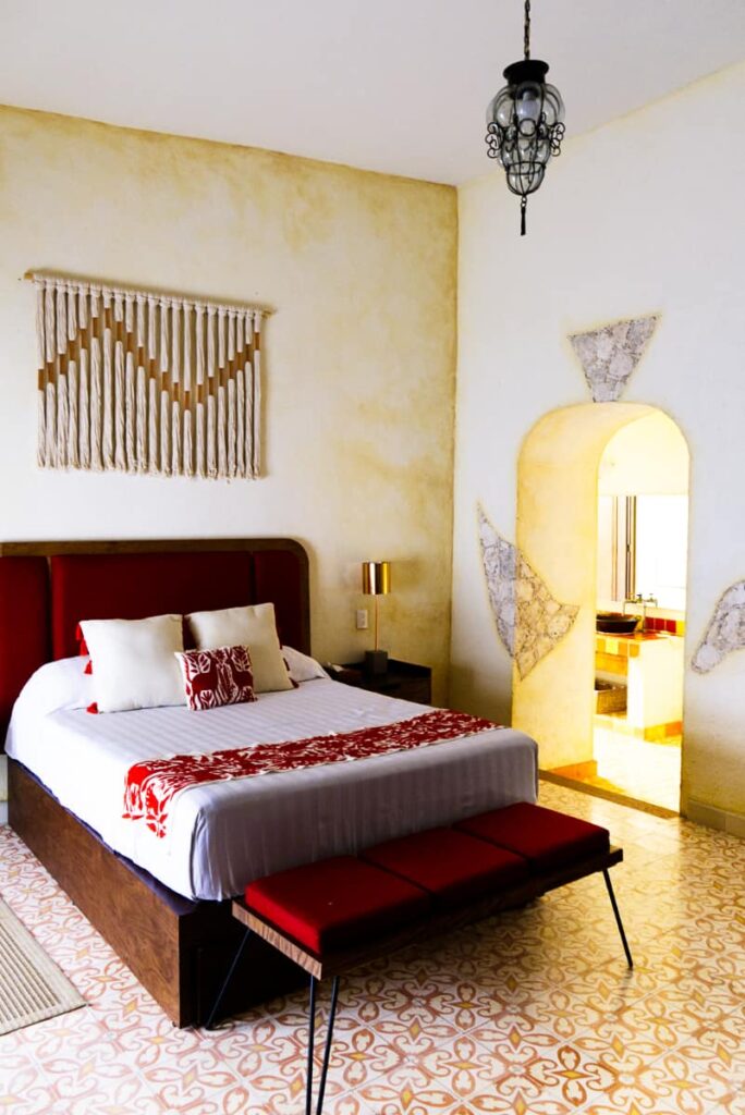 This Bernal Queretaro hotel features tall ceilings, bohemian accents, and burgundy and white fabrics.
