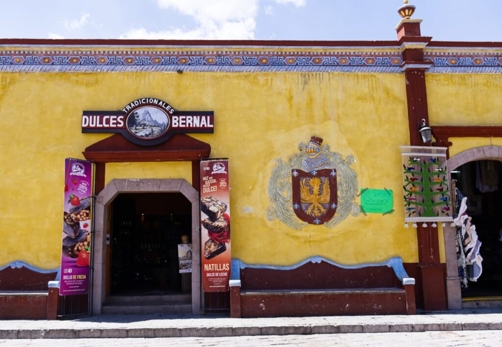 The outside of a bright yellow shop that sells traditional sweets called Dulces de Bernal.