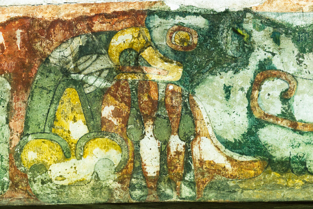 A profile of a bird with a large beak and eye is depicted in this Teotihuacan mural that features bright green, yellow, and reddish orange tones.