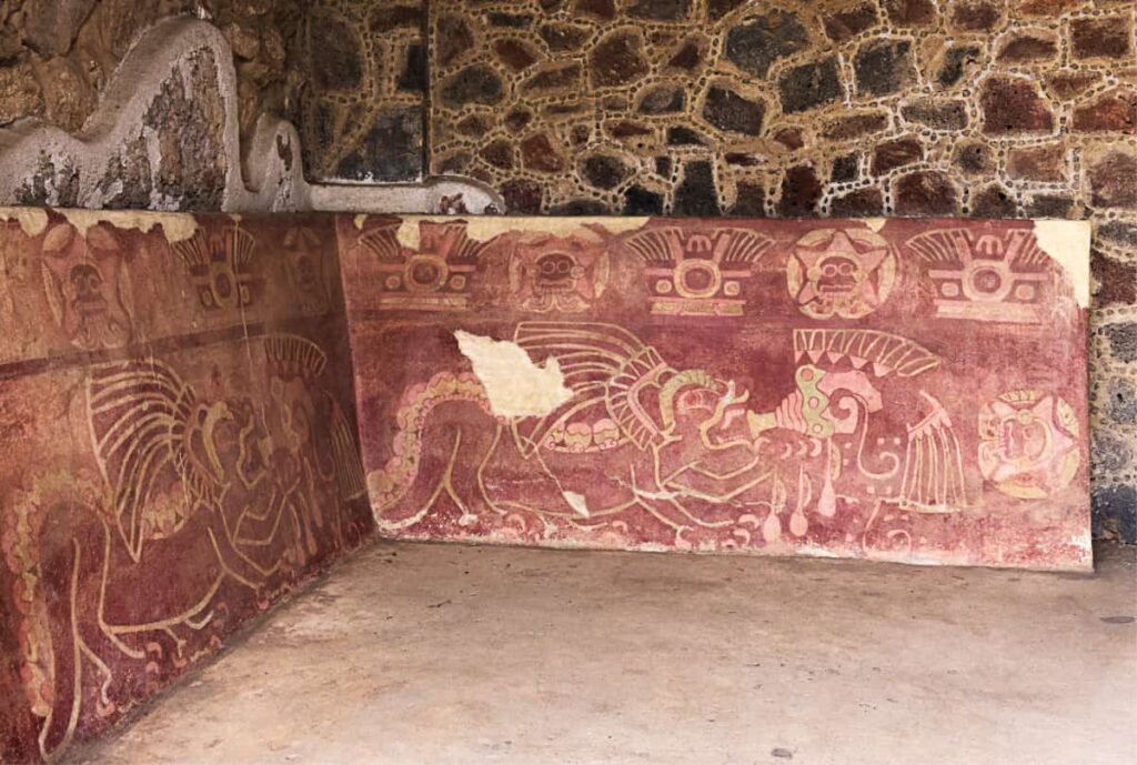 Inside the place of the Jaguars, Teotihuacan, two large painted slabs are decorated with jaguars that appear to be drinking from a vessel. The painted slabs are predominately red in color and feature other symbols.