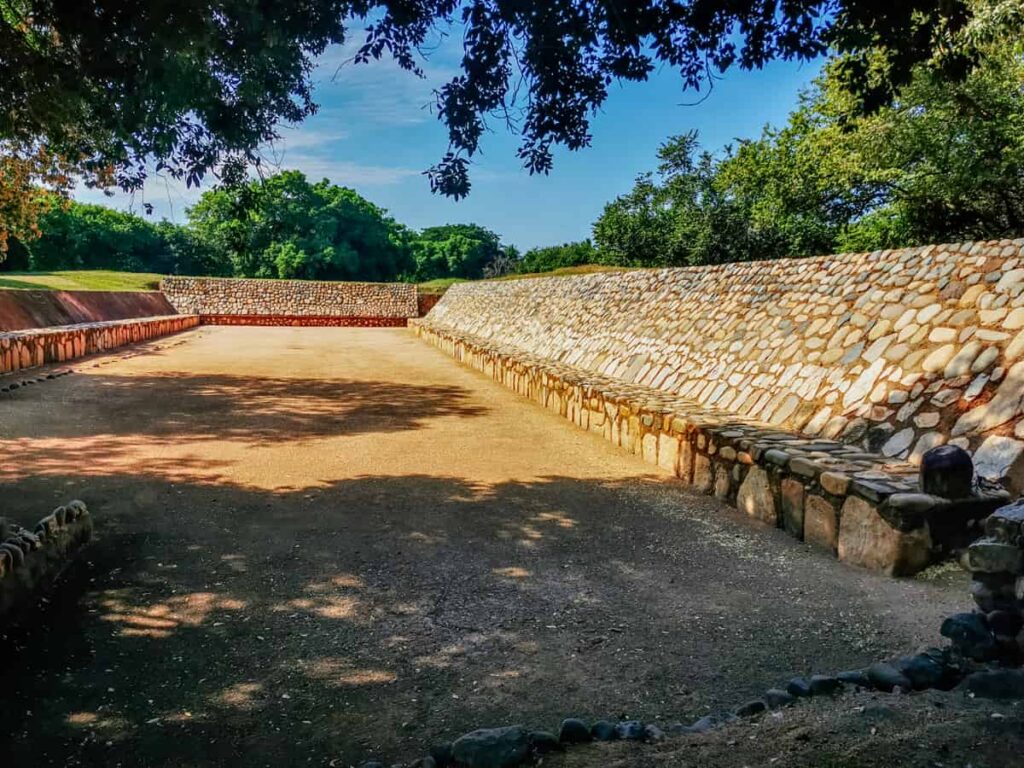 Well preserved ball court at the Xihuacan Archaeological Site near Zihuatanejo, framed by trees.