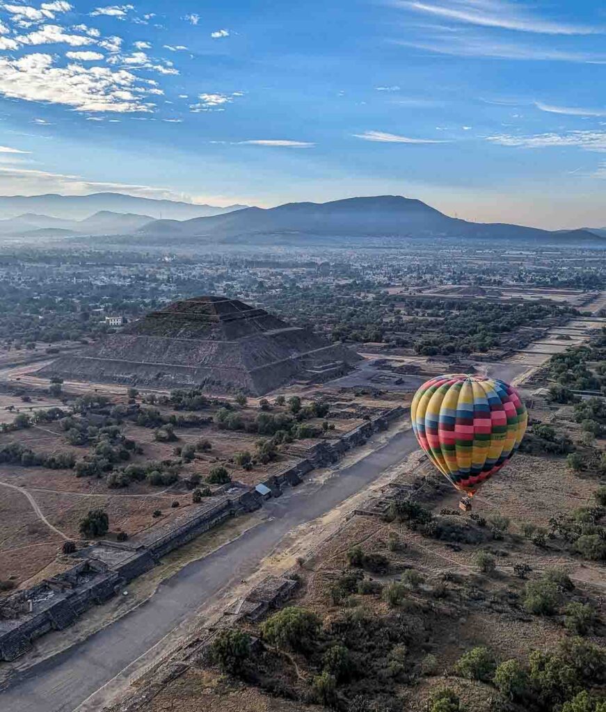 Hot air balloon soaring over Teotihuacan pyramids in Mexico City, offering breathtaking views of ancient history from above.
