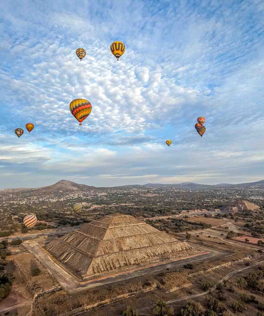 Hot air balloons floating over Teotihuacan ruins in Mexico.