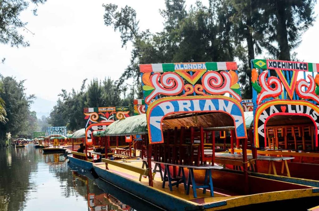 A line of brightly painted trajineras, the Xochimilco boats, on the canal nearby Mexico City.