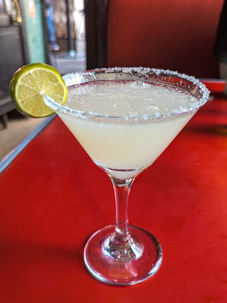 At Tio Pepe cantina in Mexico City a margarita in a salt rimmed martini glass is served with a lime.
