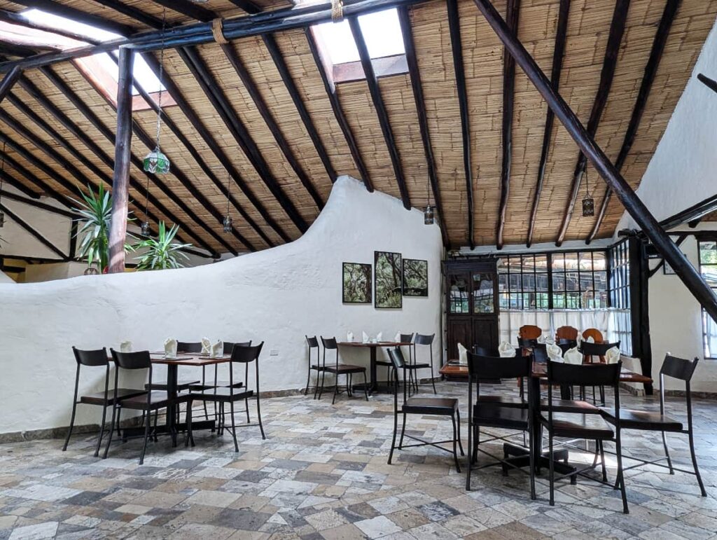 The restaurant at Papallacta hot springs resort features a wide open space with lots of natural light and tables set with linen napkinds.