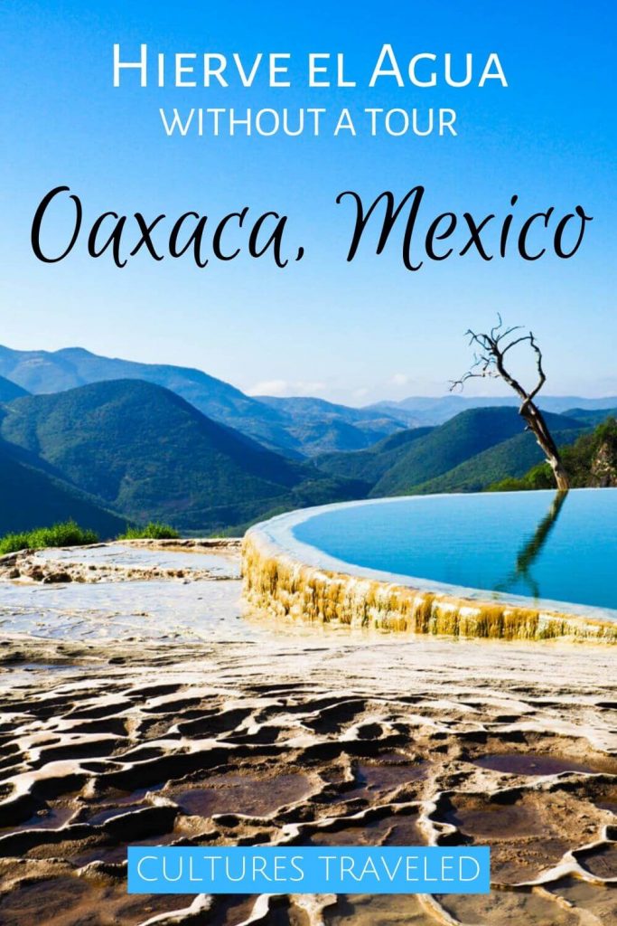 The natural pool with dry waterbeds in the foreground and mountains in the background. The text overlay reads Hierve el Agua without a tour. Oaxaca, Mexico.