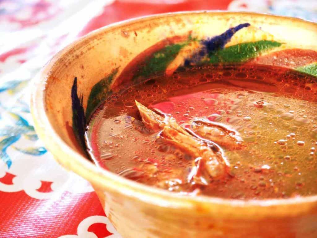 Stewed barbacoa meat peeks out from the top of a bowl of broth at the Tlacolula Market.