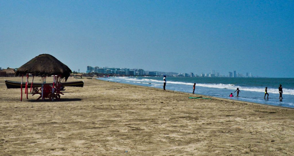 At La Boquilla, one of the beaches near Cartagena, kids play in the shallow surf with the skyline in the background.