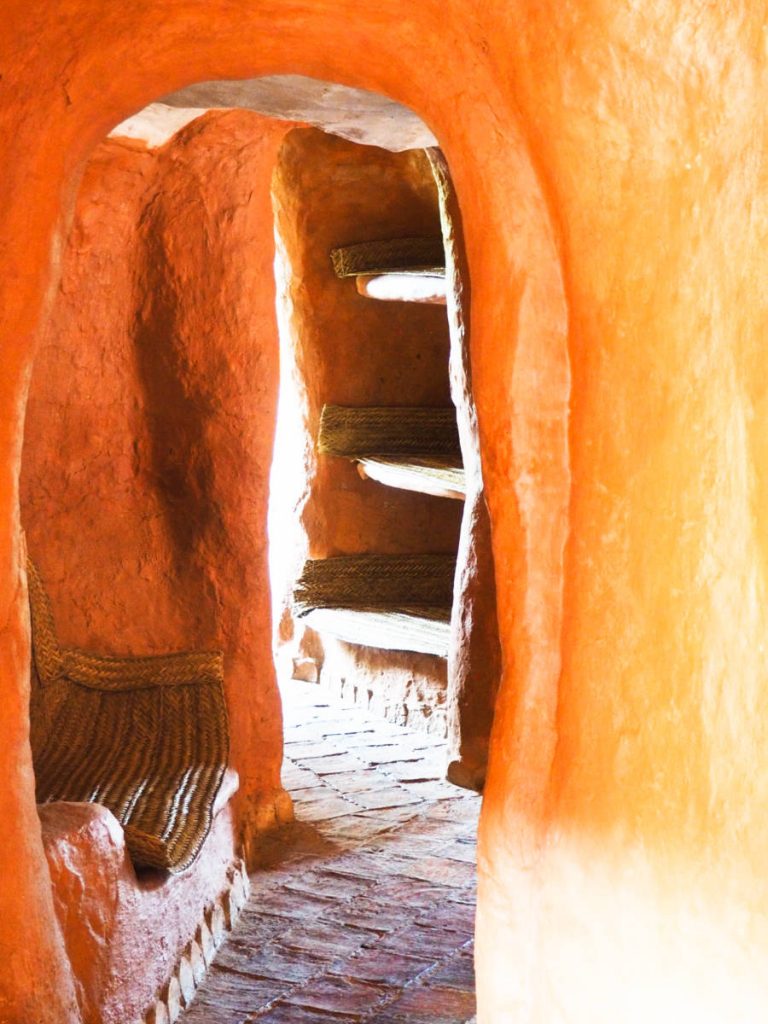 Through the arched doorways, a view of a seating bench and shelves, both built into the walls of Casa Terracota.