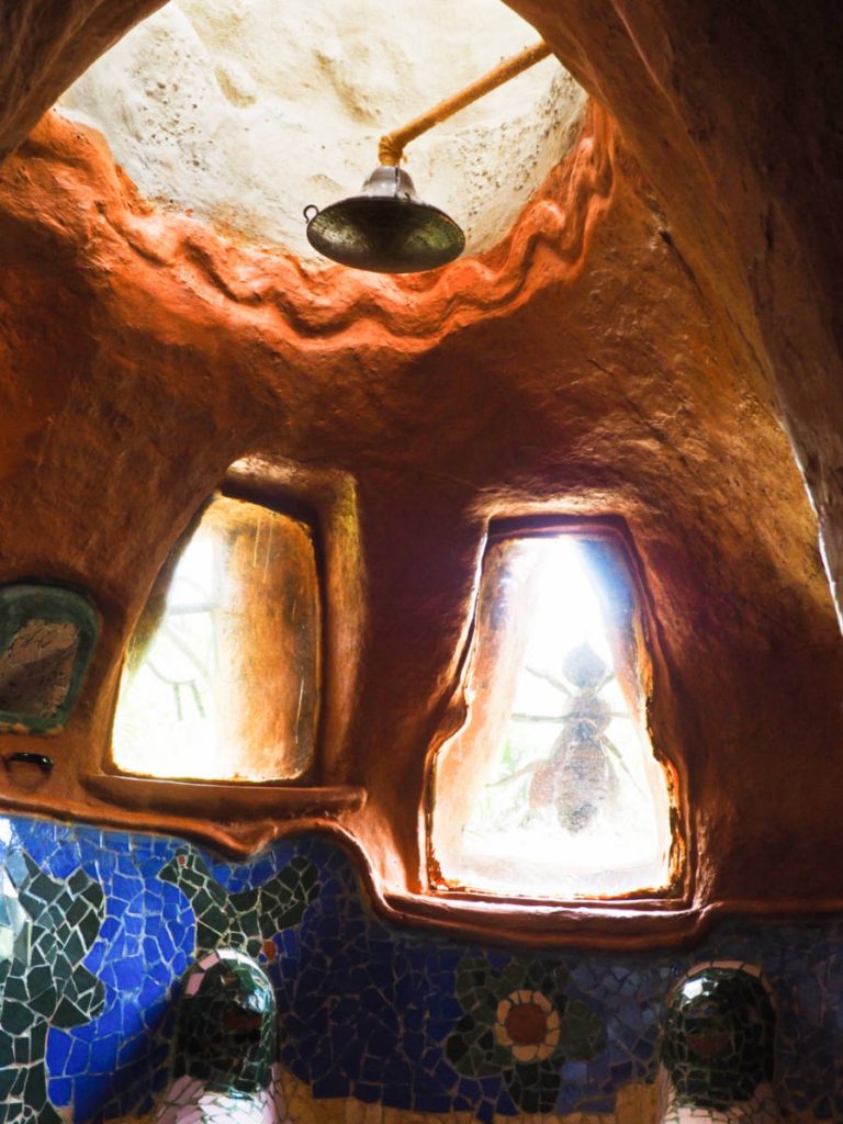 A shower head installed directly into the clay walls of the mosaic-tiled circular bathroom in Casa Terracota.