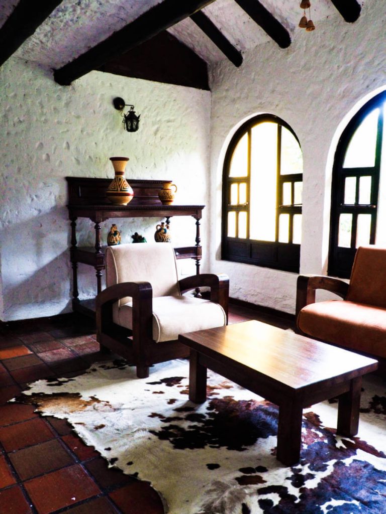 Heavy wooden and leather furniture with animal fur rug decorate the other seating area at the El Batan hot springs hotel.