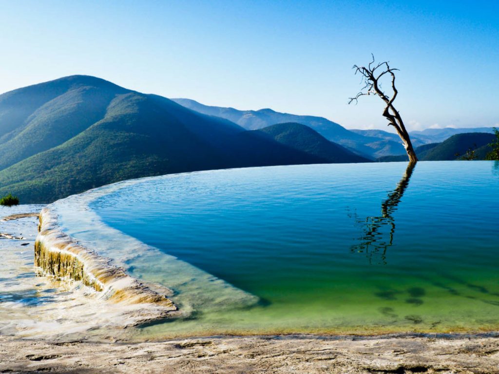 The infinity pool with hues of green and blue stretches to the edge of the cliff with nary a person in sight.