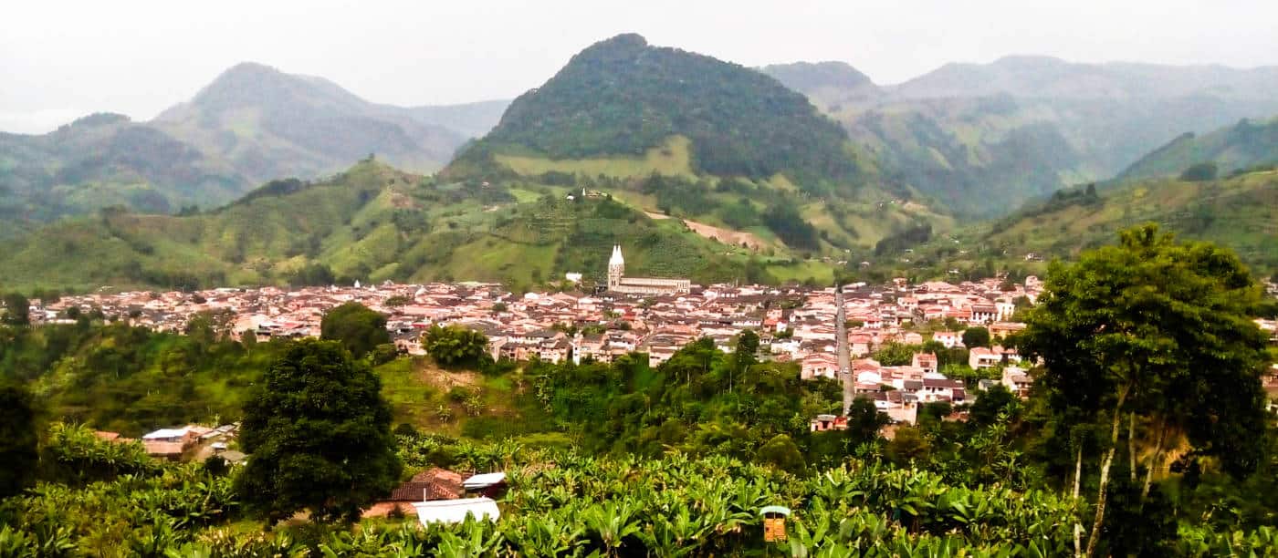 A distanced view of Jardin, Colombia with mountain peaks in the background from atop the cable car.