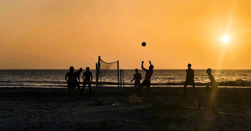 Silhouetted by the setting sun, a group plays volleyball on the beach at Zion Beach House in Playa Manzanilla.