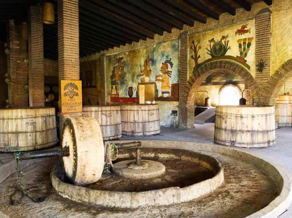 Colorful Zapotec depictions and brick archways decorate the mezcal distillery at Casa Chagoya, a great Oaxaca tour..