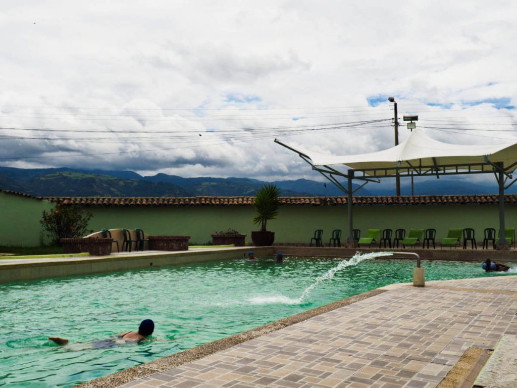 A woman swims in the thermal pool where hot thermal water is being pumping to the pool.