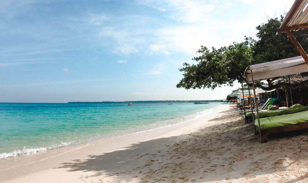 Sunbeds line the sand in front of the turquoise ocean at Playa Blanca on Isla Baru, one of the best beaches in Cartagena.