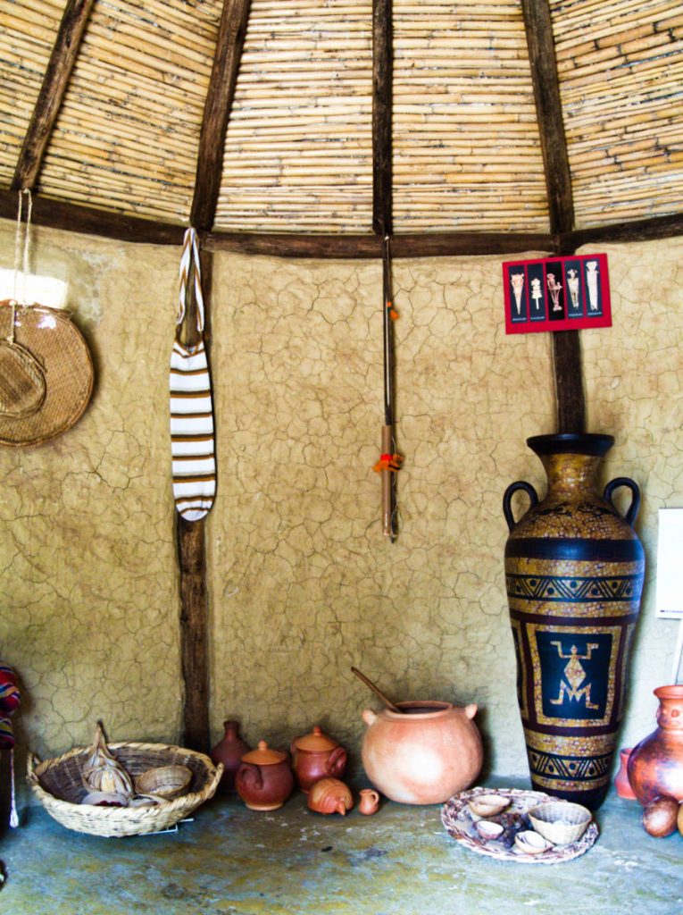 Vessels, bags, and instruments used by the Muisca people on display inside of a replica of a house at Sol Musica.