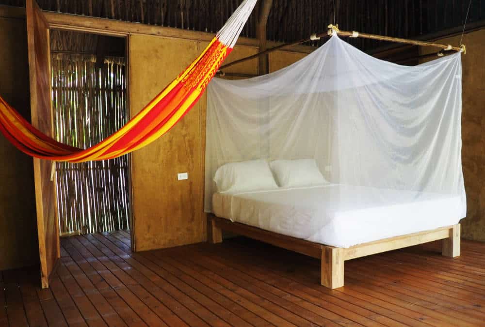 In Rincon del Mar, a hammock hangs next to the bed which is protected with a mosquito net.